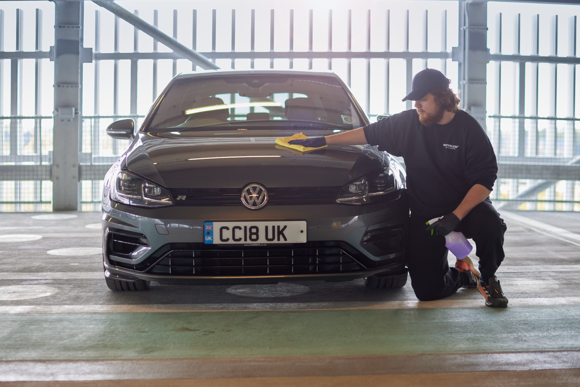 A Filth technician waterless-cleaning a car on site